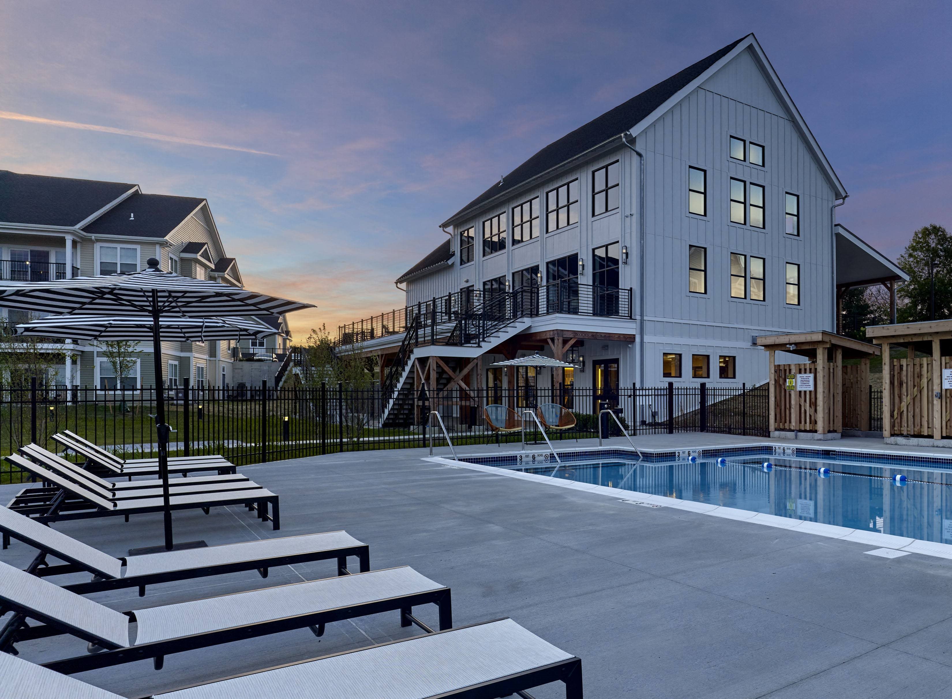 a large swimming pool in front of a white building with a